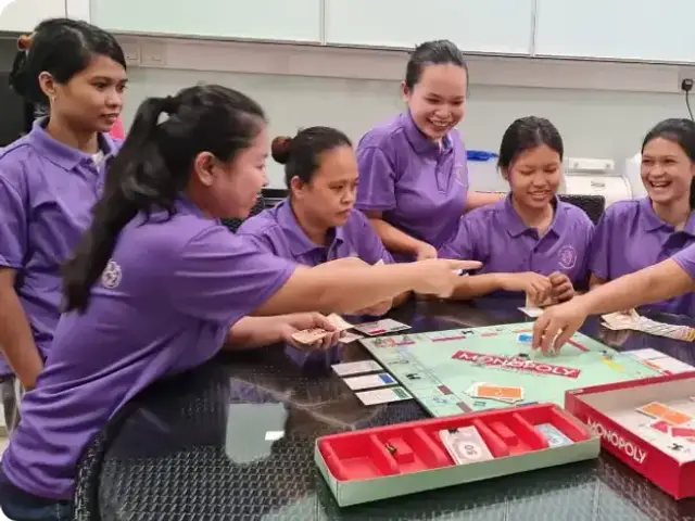 Femme5 helpers playing a board game together