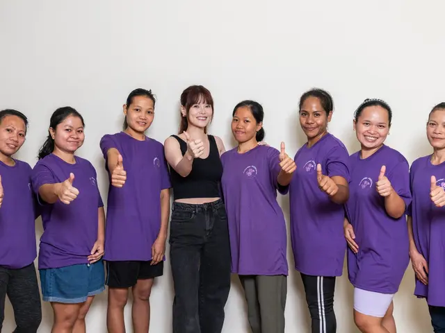 Femme5 helpers in purple T-shirts giving a thumbs up with a Femme5 consultant